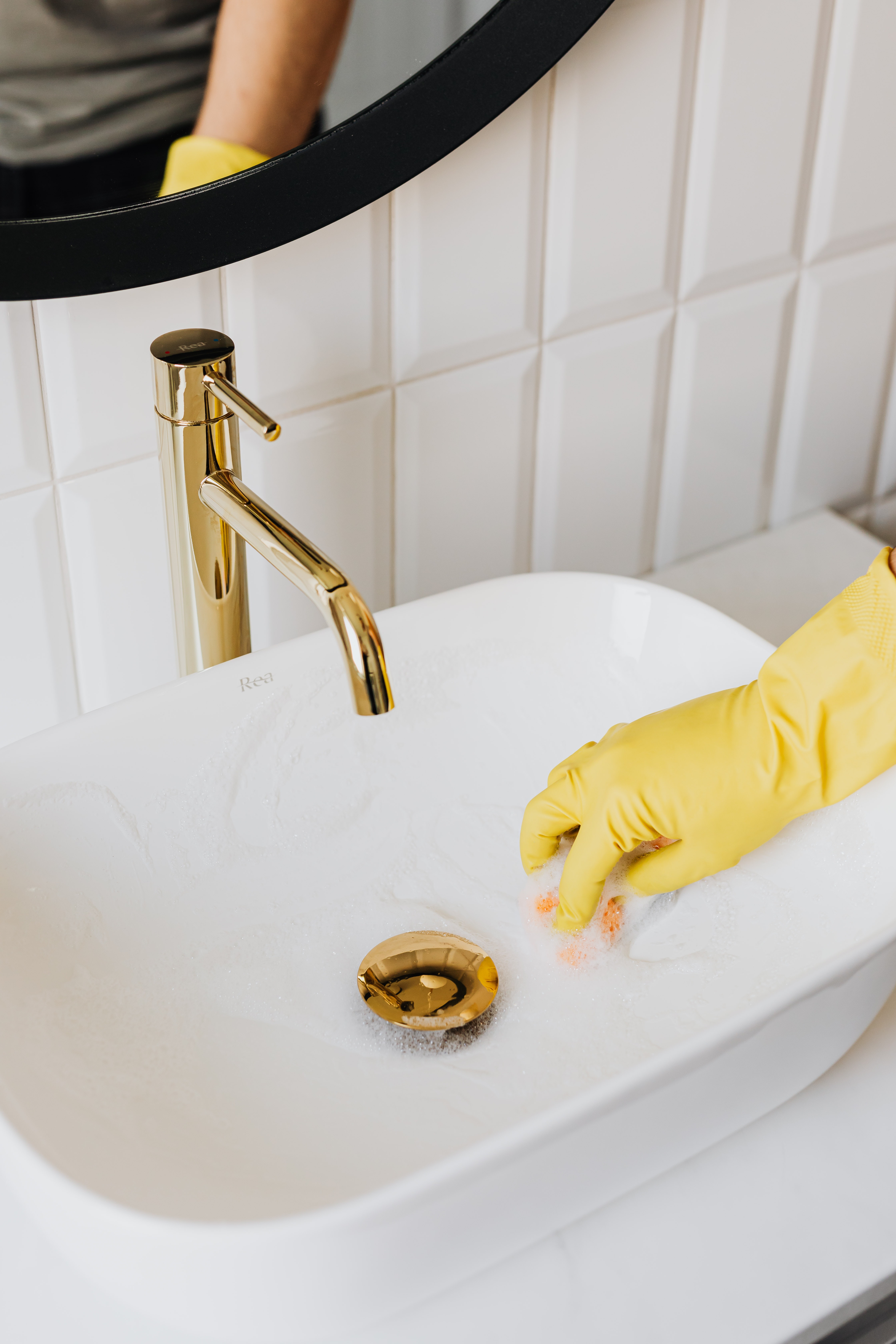 A Marvel Maids cleaner wiping a sink