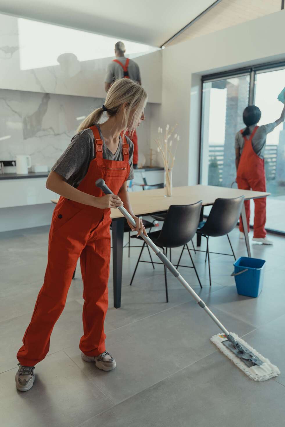 A Marvel Maids cleaner mopping a kitchen